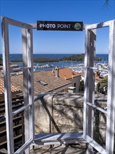 View from a Photo Point with window frame over the roofs of the town to the harbour