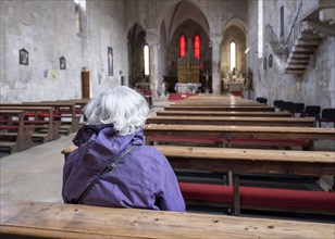 A woman sits in the Franciscan church