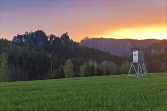 Hunter's stand on field at sunset after storm in Saxon Switzerland at Gamrig and Bastei