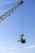 Construction crane with clamshell bucket