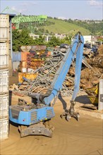 Crane with grab arm for loading scrap metal onto ships in Stuttgart harbour