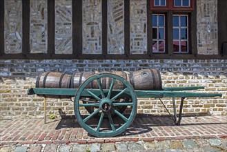 Antique handcart loaded with old wooden barrels