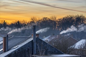 Smoking domestic rooftop chimneys from houses emitting vapour