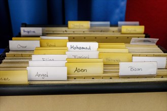 Card index box in a classroom with first names from all over the world