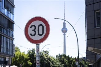 A speed 30 sign stands in the foreground of the TV Tower in Berlin
