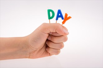 Color candles on sticks in hand write the word day