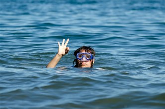 Woman with Diving Mask in the Water and Showing the Thumb Up