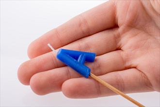 Color candle in hand on sticks writes the letterA