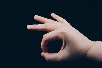 Hand gesturing sign ok okay agree on black background