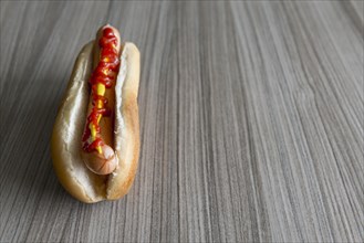Hot Dog with Ketchup and Mustard on a Wood Table