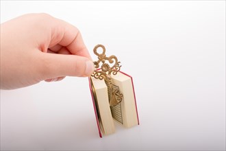 Hand holding Key and Islamic Holy Book Quran in mini size