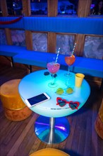 Glasses of glasses on a reserved table at a night party in a disco on vacation