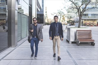 Two latin businessmen walking down the street