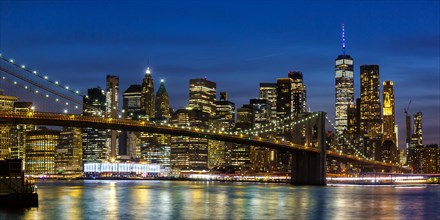 New York City Manhattan skyline with Brooklyn Bridge and World Trade Center skyscraper at night Panorama in New York
