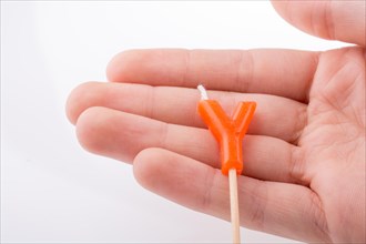 Color candle in hand on sticks writes the letter Y