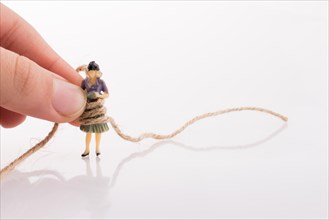 Woman figure in hand tied with a linen thread on a white background