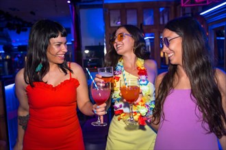 Female friends in a nightclub having fun dancing at a summer night party in a pub