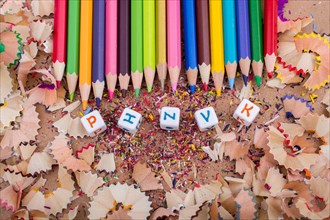 Color Pencils and letter cubes on the pencil shavings