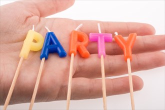 Color candles in hand on sticks write the word party