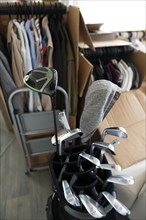 Moving House with Cardboard Boxes and Clothes and Golf Bag with Golf Clubs in Living Room in Switzerland