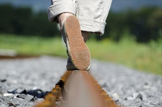 Balance with Her Feet on Railroad Tracks