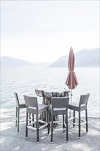 Chair and Table on the Waterfront with Mountain in Ascona