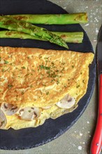 Mushroom omelette with wild asparagus on a slate