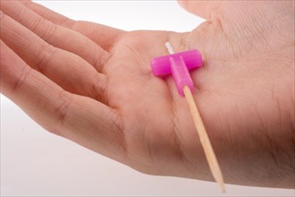 Color candle in hand on sticks writes the letter T