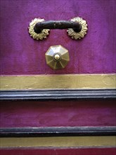 Golden knocker on a wooden door