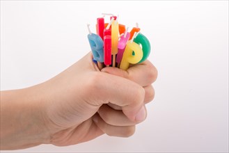 Hand holding letters made of candles on sticks