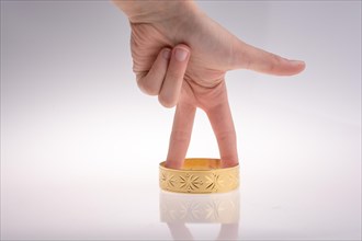 Hand with a golden bracelet on a white background