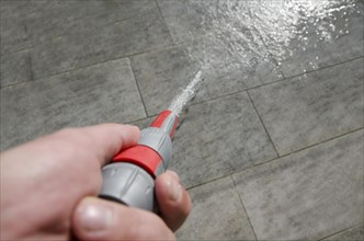 Cleaning Floor with a Water Hose