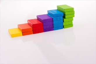 Multi color domino forming stairs on white background
