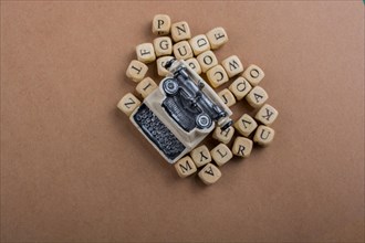 Letter cubes of made of wood around model typewritter