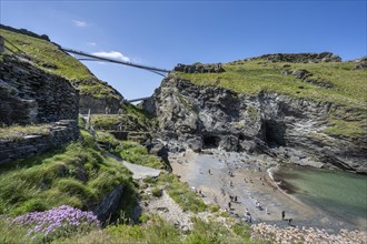 Viewing platforms on the cliffs of Tintagel with the old and new footbridge to the ruins of Tintagel Castle and the fabled Merlins Cave