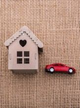 Model car and a little model house on a canvas background