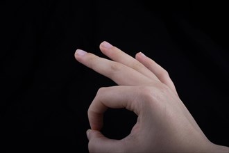 Hand gesturing sign ok okay agree on black background
