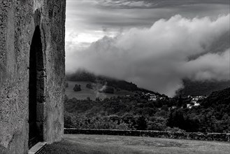 Church Door with View over Alpine Village Novaggio in the Clouds with Mountain View in Ticino