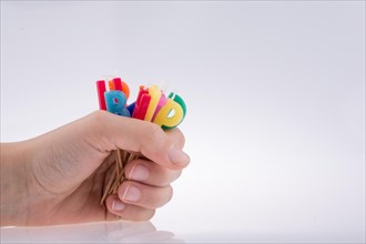 Hand holding letters made of candles on sticks