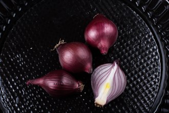 Red onion bulb cut in half on a certain background
