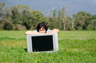 Happy Woman Leaning on a TV on the Field in a Sunny