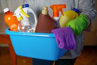 Woman holding a blue bucket with eco-friendly cleaning products.household cleaning concept