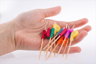Hand holding letters made of candles on sticks