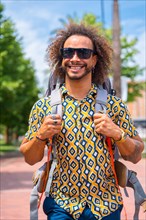 Portrait of smiling backpacker afro hair man on summer vacation