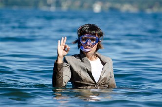 Business Woman with Suit and Diving Mask in the Water and Showing OK Signal