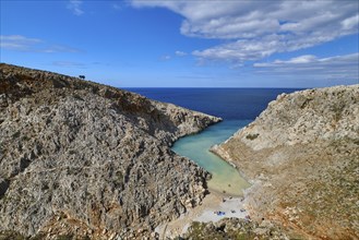 Beautiful view of z-shaped cove or lagoon in typical hills of Crete landscape. Clear blue sky and beautiful clouds on sunny day. Azure sea waters. Stefanou beach