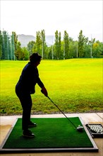 Golfer Training Her Golf Club Driver on Driving Range in a Rainy Day in Switzerland