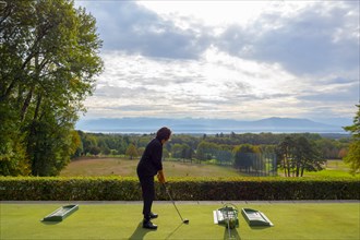 Woman on Driving Range with Panoramic View over Lake Geneva and Mountain in Switzerland