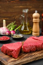 Raw uncooked beef tri-tip loin steaks with spice and seasoning on background
