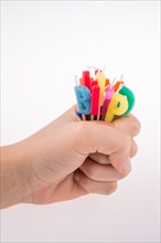 Hand holding letters made of candles on sticks
